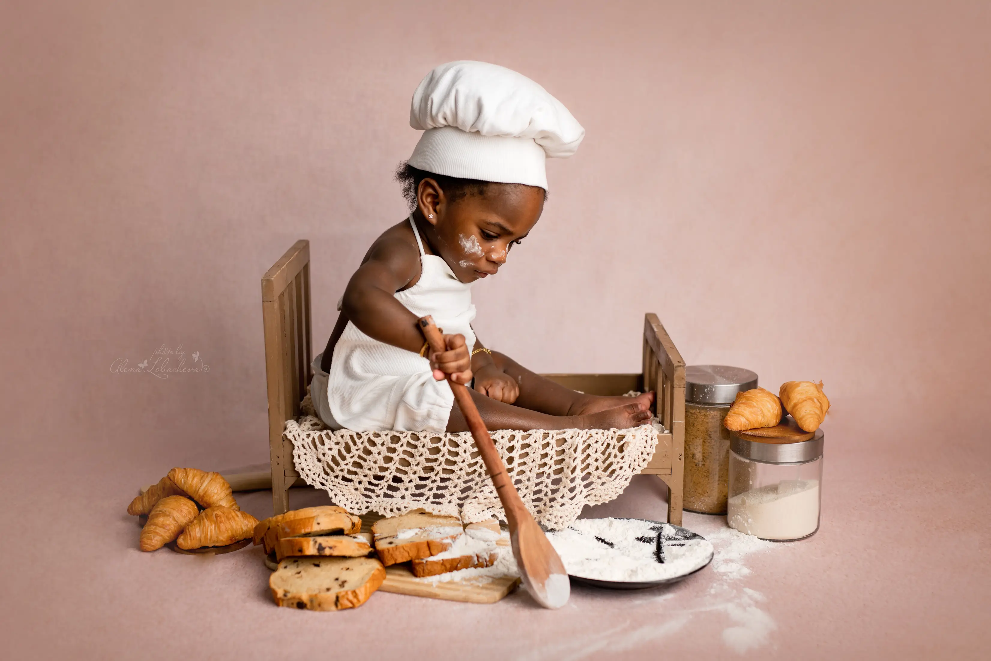 Baby dressed as a baker during a playful studio milestone session