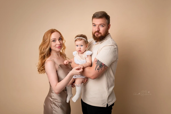 Mother and father holding their baby during a neutral studio portrait