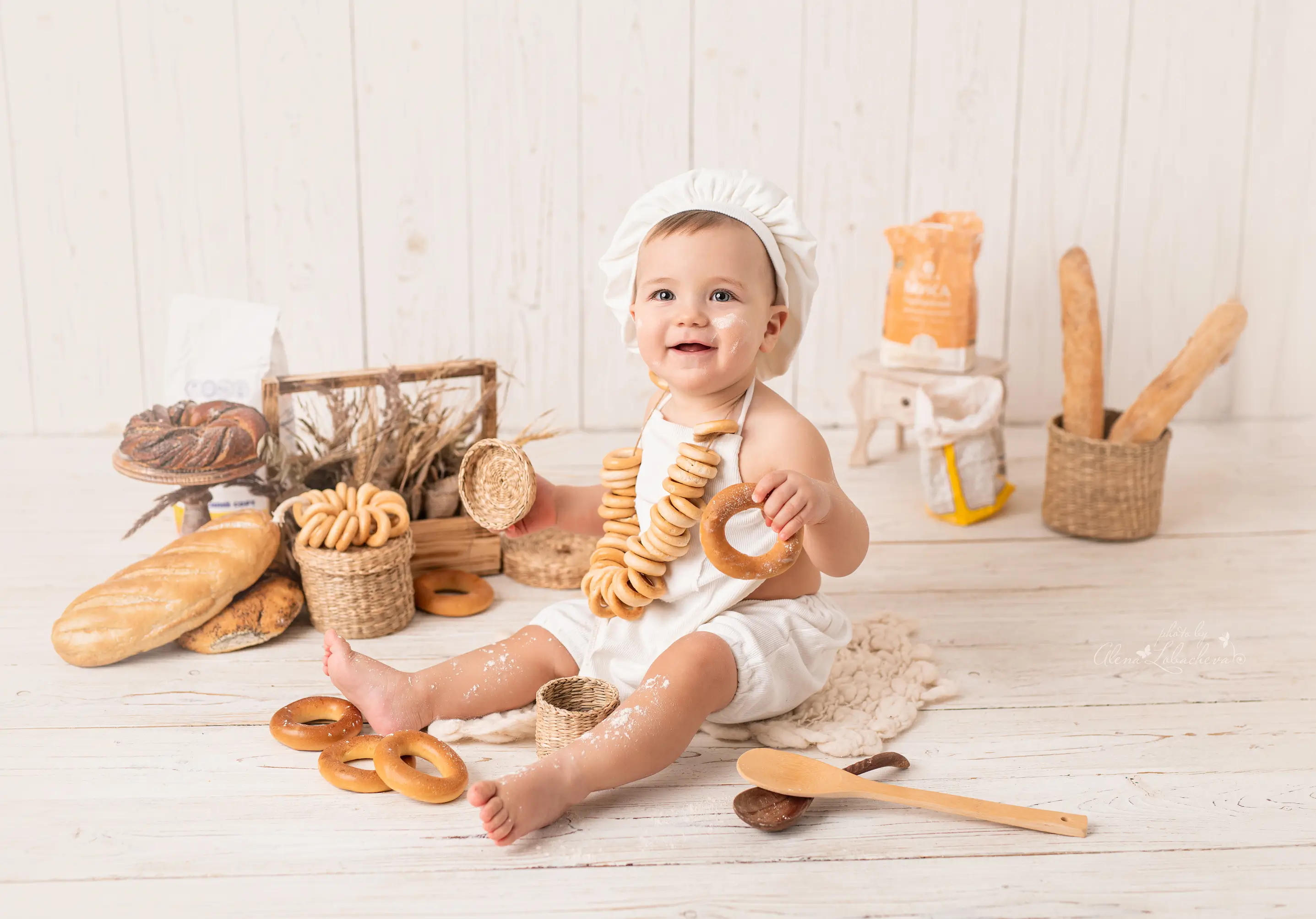 Baby posing in a bakery-themed first birthday studio set