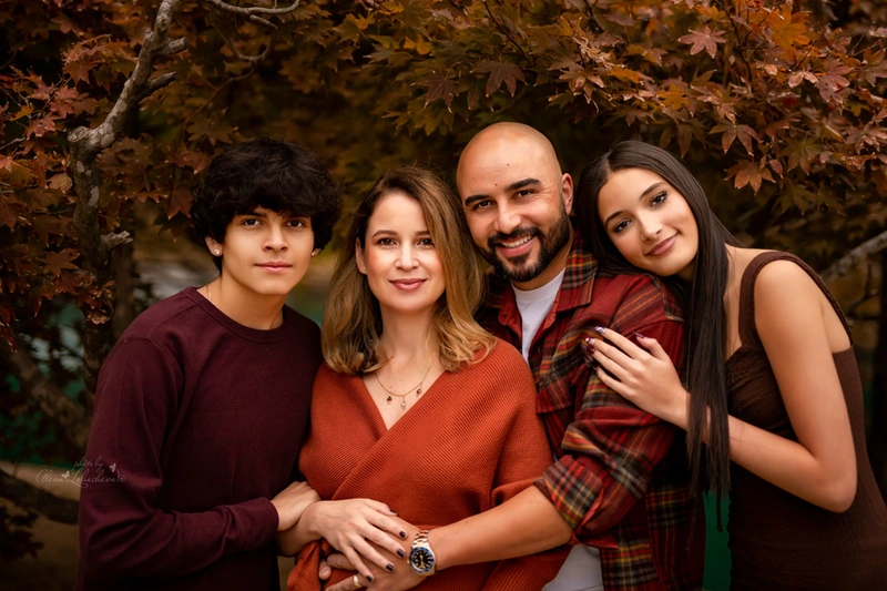 Family wearing coordinated warm fall colors for an outdoor portrait
