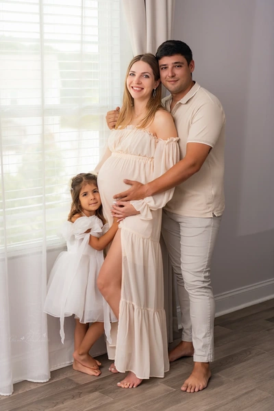 Expectant mother with her partner and daughter during a maternity session at home