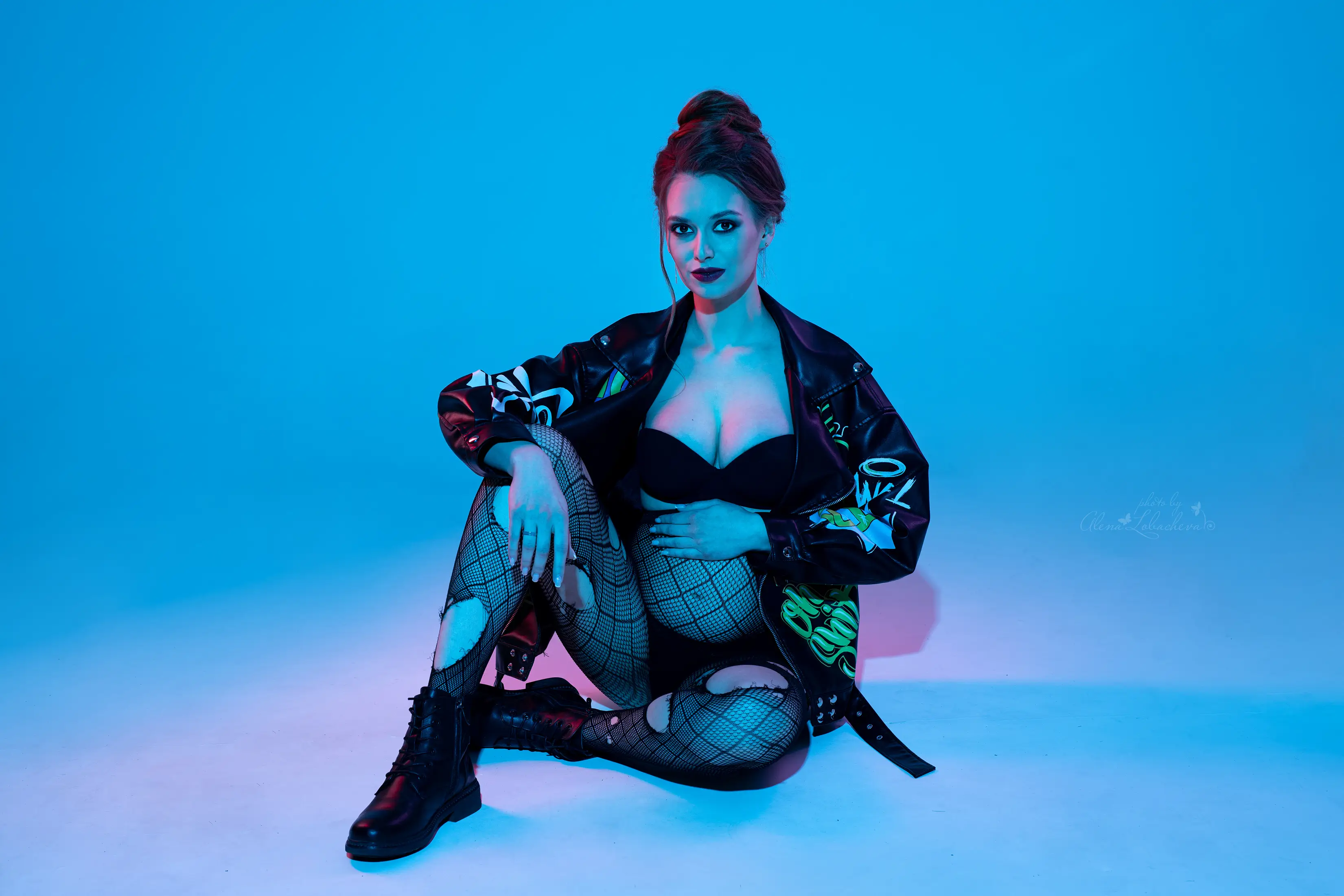 Pregnant woman wearing a modern black outfit during a colorful studio maternity session
