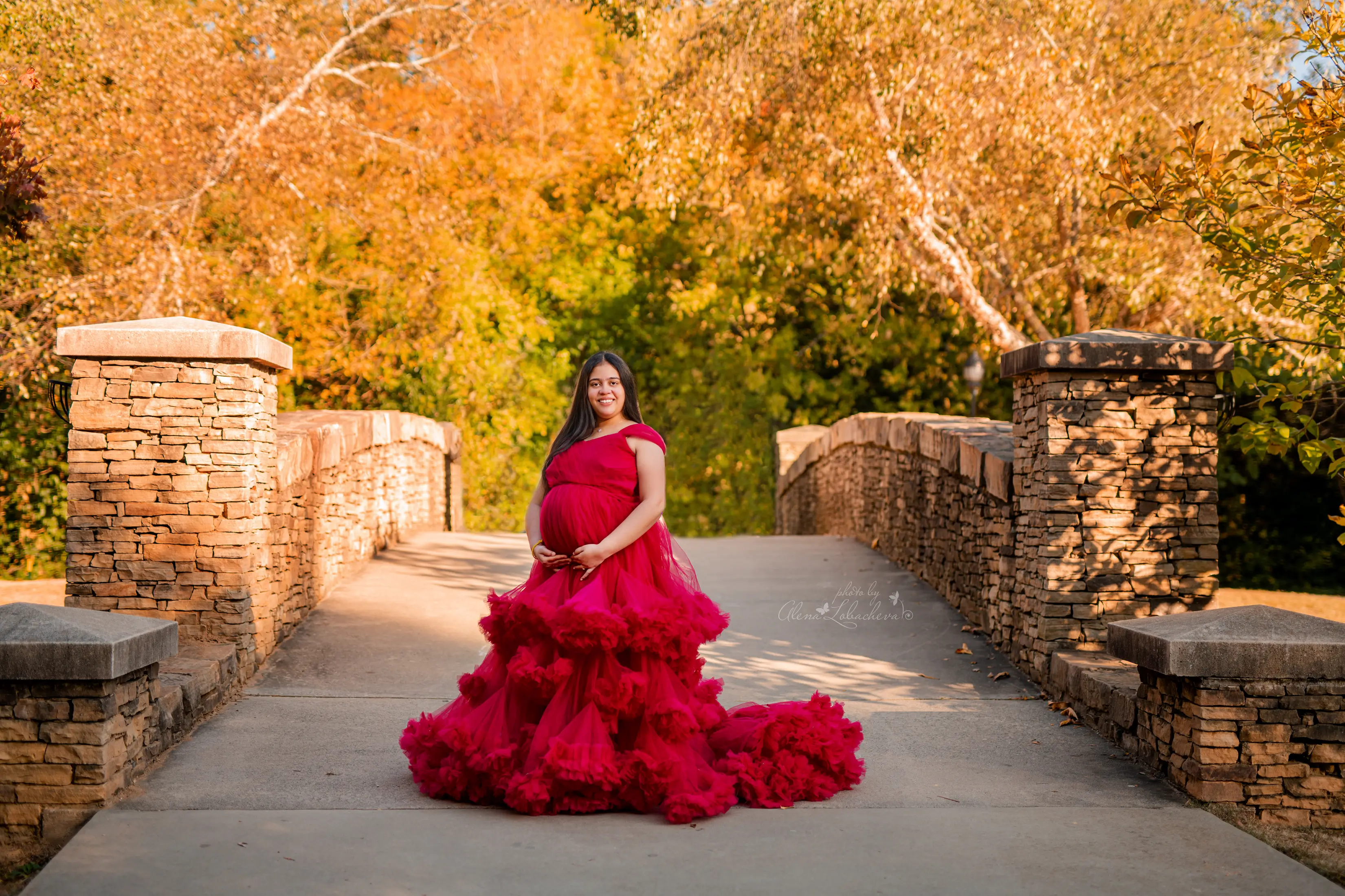 Expectant mother in a flowing dress during a maternity portrait session