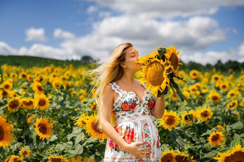 Expectant mother posing in a sunflower field during a maternity session