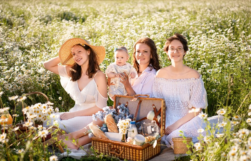Extended family enjoying a summer picnic in a field of daisies