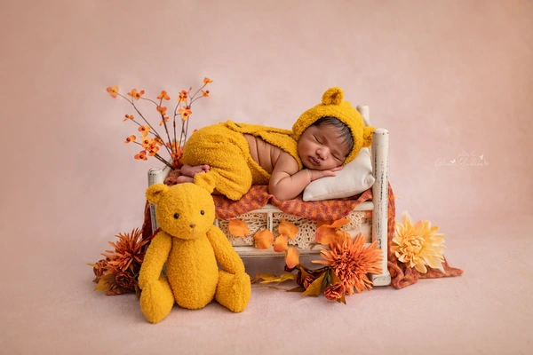 Sleeping newborn baby in a warm bear-themed portrait