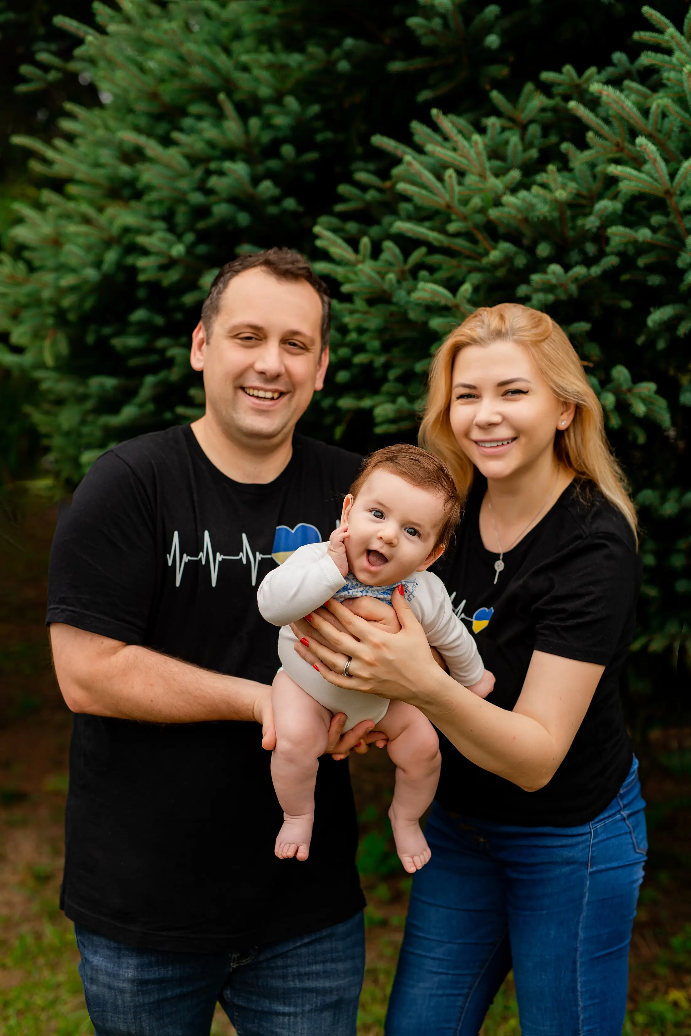Parents and baby wearing coordinated casual outfits outdoors