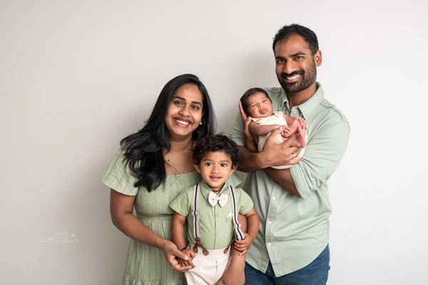 Parents and older brother posing with their newborn baby during an in-home family portrait